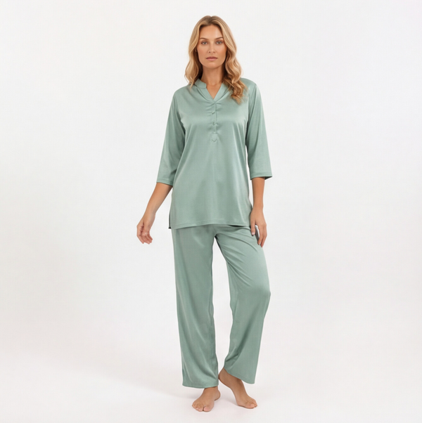 Woman wearing a green pajama set on a white background