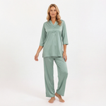 Woman wearing a green pajama set on a white background