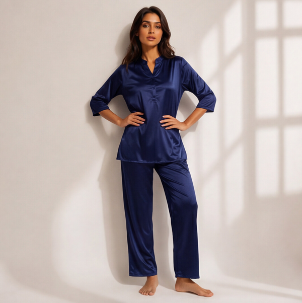 Woman wearing a midnight sapphire blue satin-look lounge set with a split-neck top, three-quarter sleeves, and matching straight-leg pants.